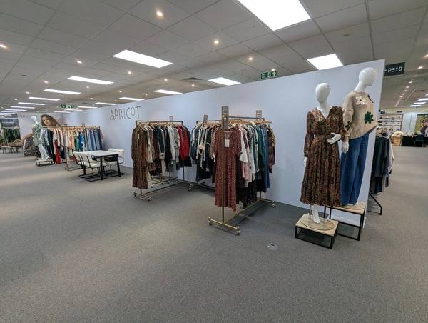 A 15m long seamless print for clothing brand apricot, with rows of clothes racks in front of the modular wall.